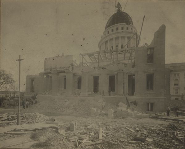 Construction debris litters the ground around the fourth Wisconsin State Capitol (third in Madison) as reconstruction of the capitol proceeds after the 1904 fire.