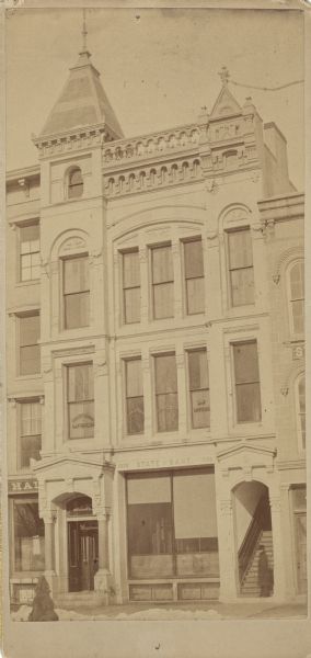 The State Bank, on Pinckney St and E. Washington, was built in 1882 to replace the original bank built in 1852. Lucien S. Hanks was the president of the State Bank from 1890 until about 1925. This view, from across the street, shows his son Stanley C. Hanks' law office, Buell and Hanks, on the second floor, left side. On the right are two other law offices.