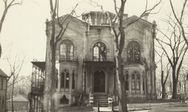 View of the front of the McDonnell-Garnhart residence, 424 North Pinckney Street. This Romanesque revival house was designed in 1857 by Samuel H. Donnell, the architect for the third Wisconsin Capitol, for contractor Alexander A. McDonnell. The latter used the same Prairie du Chien sandstone that was employed in building the Capitol, a project for which he also served as a contractor that year. 

(Building also known as Pierce House, Garnhardt House, McDonnell House, Mansion Hill Inn.)