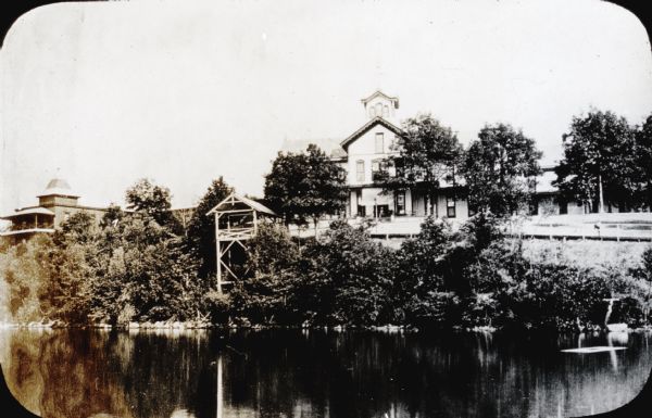 View across Lake Monona towards the Tonyawatha Spring Hotel. The hotel, on the east shore of the lake, is located in Blooming Grove Township, just outside of Madison. On July 31, 1895, the hotel was destroyed by a fire.