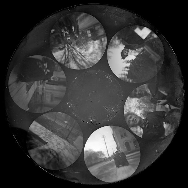 Six circular images, of small groups of people in a variety of activities, on a glass plate negative from the Stirn Concealed Vest Camera.