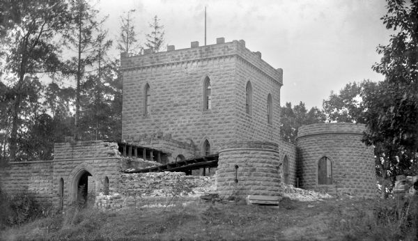 Exterior view of the disintegrating Benjamin Walker Castle in the 900 block of E. Gorham Street. The castle was built by an Englishman, Benjamin Walker, about 1863. The Walkers returned to England in 1866 and the castle passed through several owners until about 1893 when the disintegrating building was de-constructed and its materials used in other buildings.