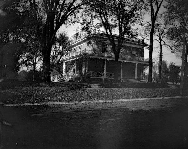 View from street of the home of James Ramsey at 302 S. Mills Street. The house was built by Seth Bergin, a farmer and real estate investor, in 1846 in the Italianate style with a cupola. Dr. James Bowen, Madison's first homeopathic physician, lived in the house from 1859 to 1881. His daughter Susan Bowen Ramsey inherited the house, as did his grandson James Ramsey.