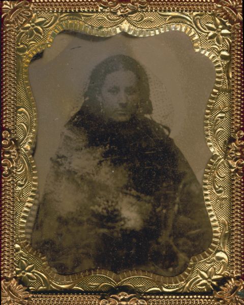 Ninth plate ferrotype/tintype. Waist-up seated portrait of Margaret Stoltz, in mourning attire, including a veil over her head. She later married and became Mrs. Bushjager. She was originally from Waukesha, Wisconsin.