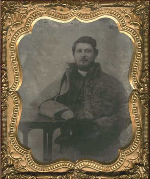 Sixth plate tintype/ferrotype of Cornelius Wheeler seated in a chair with his arm resting on a table. Wheeler was a 1st lieutenant in the 2nd Wisconsin Infantry, Company I during the Civil War. He later served as the governor of the Northwest branch of the National Soldiers' Home in Milwaukee, from 1892-1915.