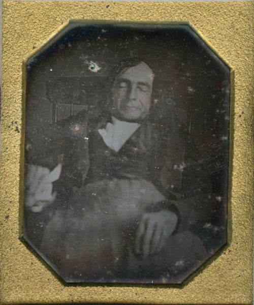 Sixth plate daguerreotype of Thomas Barlett of Old Town, Maine. He is seated, resting his arms on the arms of the chair, and holding a handkerchief. His eyes are closed. Hand-coloring on the cheeks. The photograph may have been taken postmortem.