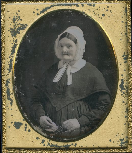 Sixth plate daguerreotype. Waist-up portrait of Elsey Ormsbee Bristol. Elsey was born May 27, 1783; married August 1, 1804 at Warwick, Massachusetts to Charles B. Bristol of Manleas New York, and died in Elizabeth, New Jersey, March 18, 1869. She is an older woman, sitting, wearing a bonnet and holding knitting needles and a piece of knitting in her lap.