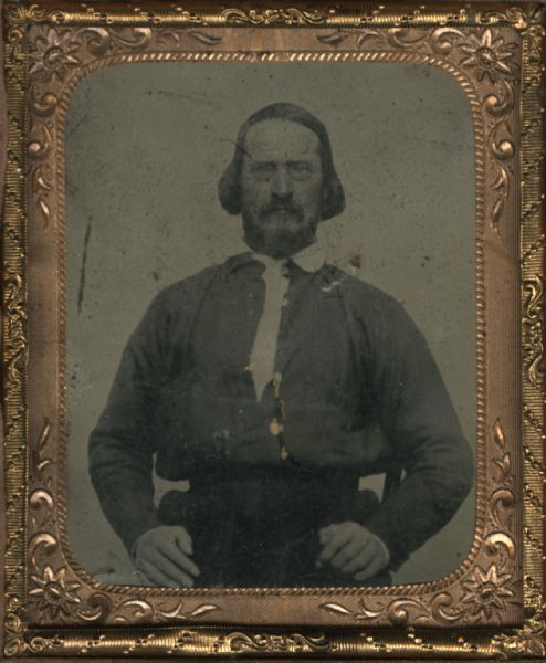 Ninth plate tintype/ferrotype portrait of Fritz Anneke sitting in a chair. Fritz Anneke was a German socialist and newspaper editor and writer. He immigrated to the United States with his family in 1849 and became a Colonel in the Wisconsin 34th Infantry. After the war he was an entrepreneur and journalist. He was the husband of Mathilde Franziska Anneke, the feminist activist and writer. Hand-coloring on cheeks.