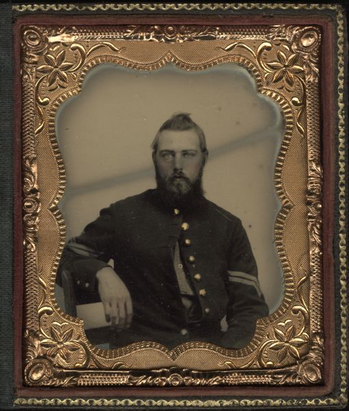 Sixth plate tintype/ferrotype portrait of an unidentified soldier from the 13th Wisconsin Infantry. He is seated with his arm resting over the back of a chair. His coat is buttoned at top and bottom cadet-style. Gold details on buttons of military uniform.
