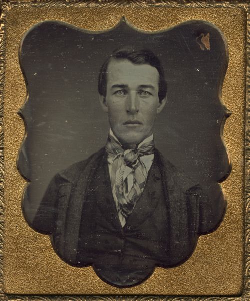 Sixth plate daguerreotype of a young man from the Ingersoll family. Half-figure, subject facing forward, wearing stand collar, plaid tie, vest, and suit jacket unbuttoned. Hand-coloring on cheeks.
