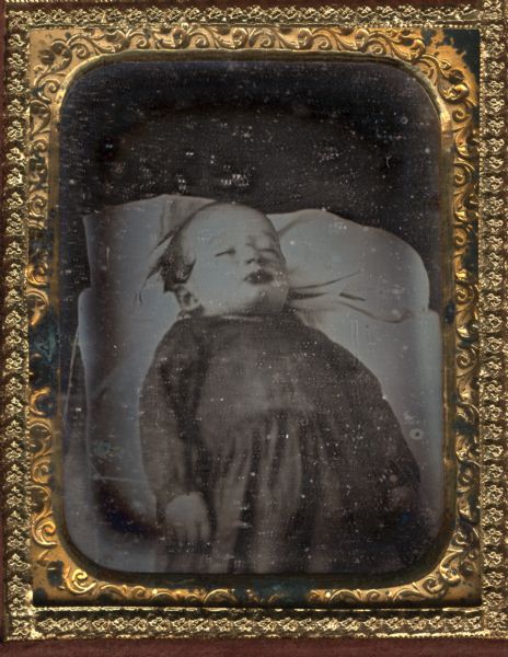 Ninth plate daguerreotype of Leroy Lumbard, taken at the age of 2 after his death. The portrait is three-quarter length with the child laying back and turned slightly to the right.