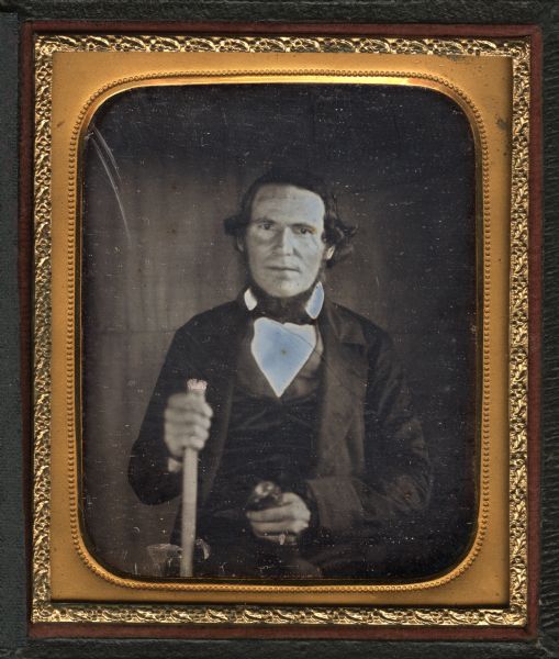 A sixth plate daguerreotype of Elijah Swan.  The subject is half length, facing front. He is holding a cane in his right hand, and an unidentified object in his left hand. Swan was a resident of Cottage Grove from c. 1830-1865.