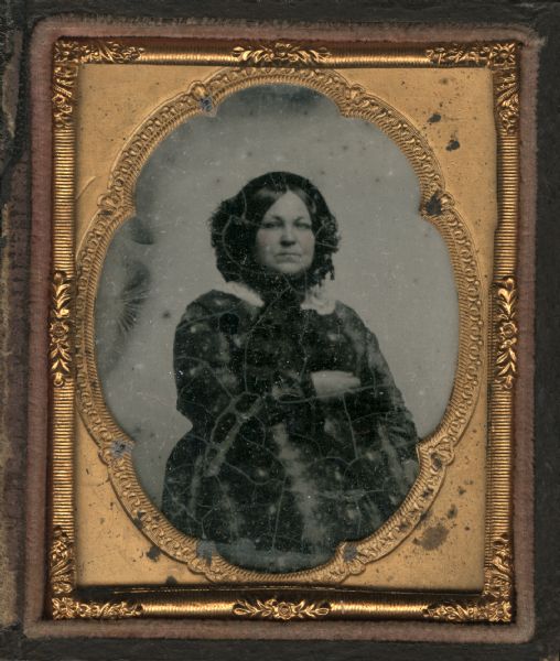 Ninth plate ambrotype of Elizabeth S. Upham (1815-1883). Three-quarter figure facing front and slightly left, wearing a bonnet. Hand-coloring on cheeks. She was born Elizabeth S. Jaques and married Don A.J. Upham.  