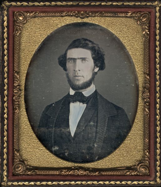 Sixth plate daguerreotype of George McCready Oakley. Half figure facing front and slightly left, wearing beard, coat with wide collar and lapels, vest, and bow tie. Hand-coloring on cheeks. 