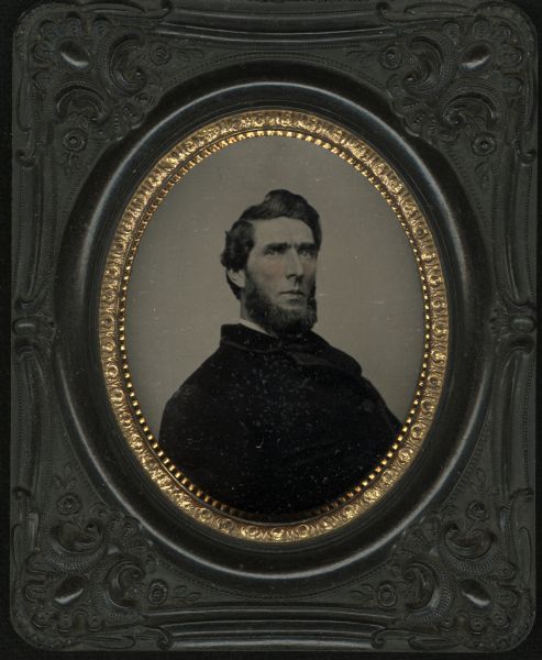 Sixth plate ferrotype/tintype of George McCready Oakley. Half figure facing front and slightly right, leaning slightly back, wearing beard and dark coat. Hand-coloring on cheeks. 