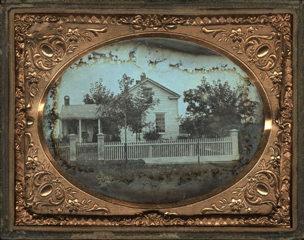 Quarter plate daguerreotype of the Cornelia Vedder house. A woman is standing on the porch. Described as the house "where George Winnie, a conductor on the Milwaukee and Prairie du Chien Railroad, stayed at the end of his run."