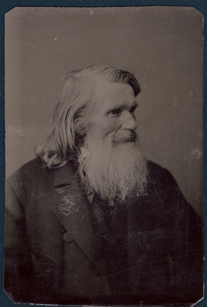 Sixth-plate ferrotype/tintype. Waist-up portrait of Theodore Bernhard, from Watertown, Wisconsin. Educator, member of the assembly in 1854. He is facing towards the right, and is wearing a suit coat. He has a long beard and a bushy moustache.