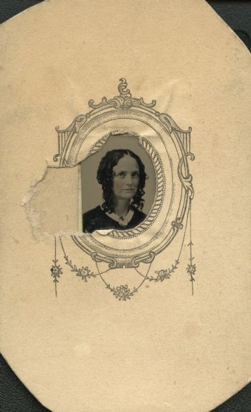 Ferrotype/tintype of Mrs. Robinson. Head and shoulders portrait facing slightly right but looking forward. She has shoulder length ringlets, is wearing a white collar, and brooch or cameo at her neck. Hand-coloring on the cheeks. 