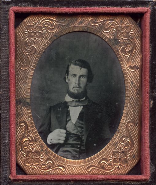 Ninth plate ferrotype/tintype of James McKesson, pioneer settler in Superior, Wisconsin. Waist-up portrait, seated, facing forward wearing a suit, tie, and satin vest, with his hand holding his lapel. He has a beard and mustache. 