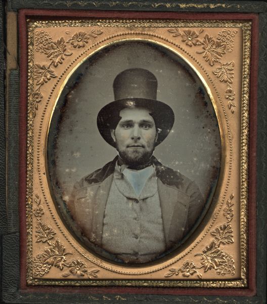 Sixth plate daguerreotype of unidentified man, probably a relative of the Chandler family. Bust portrait, facing forward, wearing light-colored suit with velvet collar and a top hat. He has a beard, and his hair is combed over his temples. Hand-coloring on cheeks. 