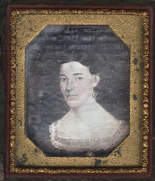 Sixth plate daguerreotype of a painting of Caroline Allcott Stone. Head and shoulders portrait, facing slightly left but eyes gazing forward. She is wearing a dark dress, lace collar, and drop earrings, with her hair drawn up above the ears. Hand-coloring on cheeks. 