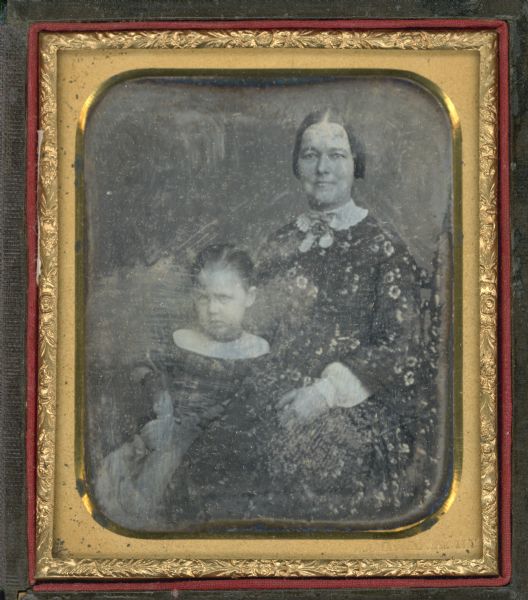 Sixth plate daguerreotype of Lydia Remsen Draper sitting in a chair, (Mrs. Lyman C. Draper, Dr. Draper's first wife) and adopted daughter Helen, (died 1864) sitting next to her with a doll in her lap. 