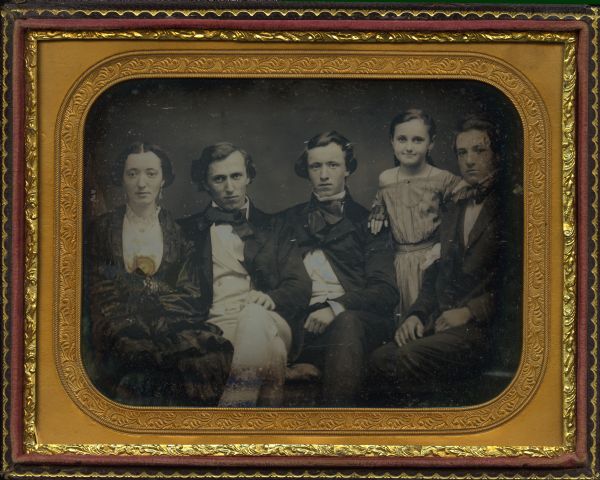 Half plate daguerreotype of the Burrows siblings, children of Reverend Baxter Burrows and Lydia Boynton Burrows of Montpelier, Vermont. Left to right: Florella P., George B., Frank W., Helen A., and Henry J. Burrows. All are seated except for the younger girl, Helen, who is wearing a necklace, earrings and mitts, and is standing with her arm on Henry's shoulder. Florella's arms are folded, and George (in white trousers) and Frank slouch comfortably. 