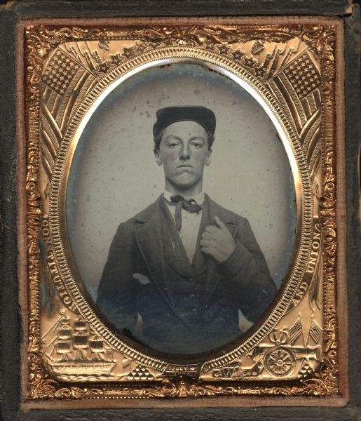 Sixth plate ambrotype of Franklin Hoyt (1846-?). Waist-up portrait facing front, with left hand on his lapel. He is wearing a suit, small bow tie, and cap with upturned brim. Hand-coloring on cheeks. The portrait was taken in Port Washington, Wisconsin when he was 16. Born in New Orleans, Hoyt enlisted in Co. I, First Wisconsin, Heavy Artillery, at Port Washington in October 1864, giving his age as 19. He achieved the rank of Drummer, and his drum and fife are in the Wisconsin Historical Museum collections.