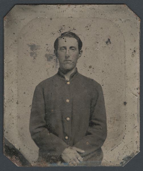 Ferrotype/tintype of Franklin B. Howard. Waist-up portrait, facing forward, with hands folded in his lap, and wearing a uniform coat. Hand-coloring on cheeks and buttons. Howard was from Waupun, Wisconsin, and joined Company K, 10th regiment, Wisconsin volunteers. He died at Andersonville Prison after his capture at Chickamauga. 