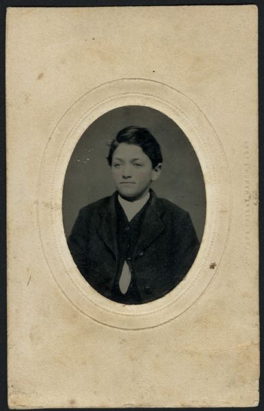 Ferrotype/tintype of John C. Frazee, 1857-1929. Quarter-length portrait facing slightly left, wearing suit coat, vest and white shirt. Hand-coloring on cheeks.