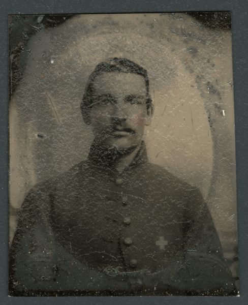 Ferrotype/tintype of Levi Bartlett, Company G, 37th Massachusetts Volunteer Infantry. Quarter-length portrait facing forward, in uniform jacket with white cross on breast pocket and two stripes on left sleeve. Hand-coloring on cheeks.