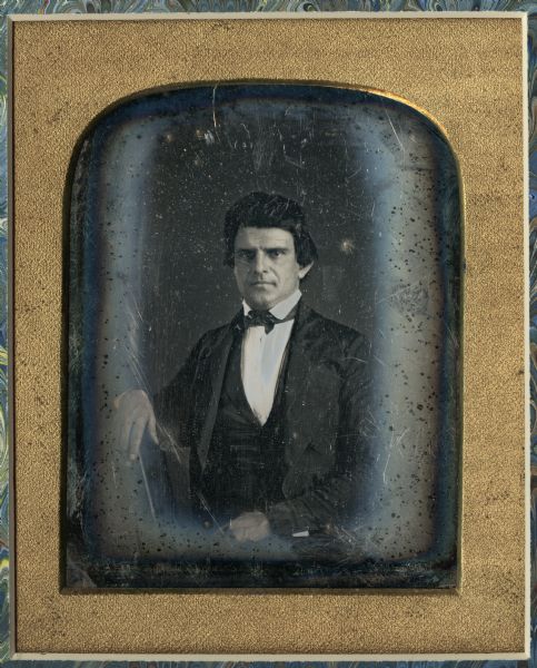 Half plate daguerreotype of Nelson Dewey (1813-1889). Waist -up, facing forward, wearing suit and with right arm resting on a surface. Dewey was Governor of Wisconsin from June 7th, 1848 until January 5th, 1852.