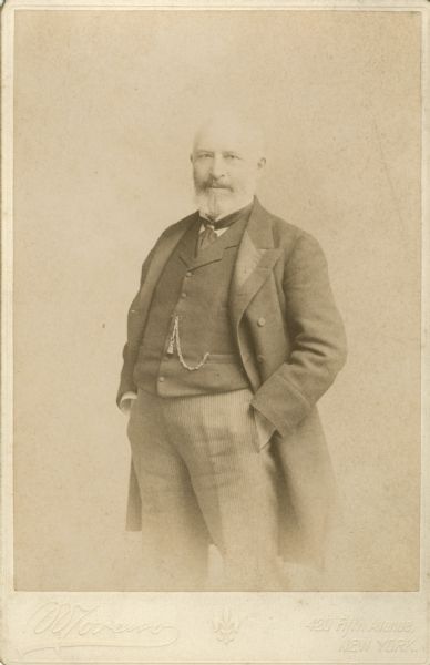 Three-quarter length portrait of Frederick Layton who is standing with his hands in his pockets. Layton was the son of a Milwaukee butcher and ran the business until his retirement. He used his fortune to build the Layton Art Gallery and also contributed to the Layton Home for Incurables.