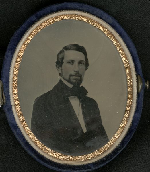 Waist-up oval-framed tintype portrait of a young Frederick Layton, about 30 years old, in a blue velvet oval compact.