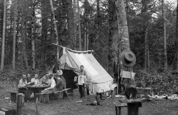 A group of men sharing a meal at a fishing camp near Thunder Lake.