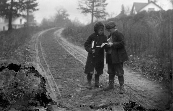 Muriel and Laurie Peterson, stopped on a country road near Scandinavia, looking something up in a dictionary.