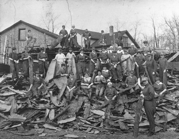 A group of women employees of the N.R. Allen Tannery posing with a pile of tan bark.