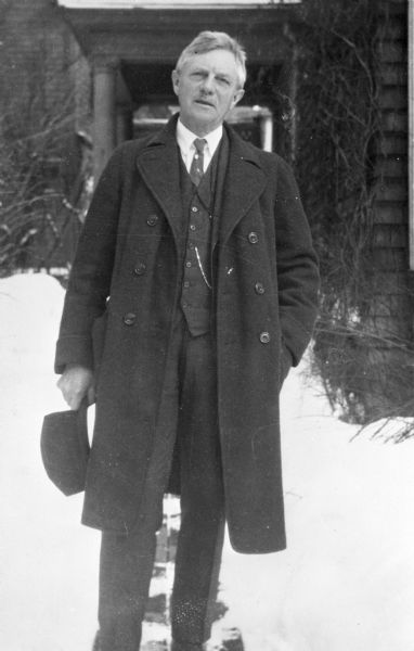 Outdoor portrait of Frederick J. Turner wearing an overcoat and standing in the snow. Location is 7 Phillips Place, Cambridge, Massachusetts.