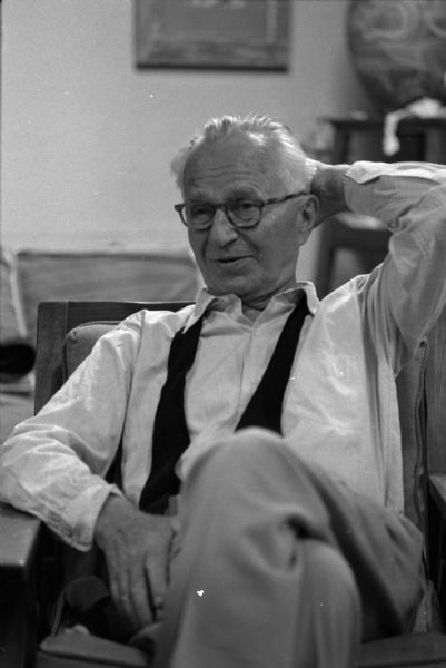 Casual portrait of Edward Steichen (1879-1973), photographer and filmmaker, sitting in Aaron Bohrod's studio on the university campus at an informal party for Steichen. Steichen was the director of the Department of Photography at the Museum of Modern Art in New York City. Bohrod was the artist-in-residence at the University of Wisconsin in Madison.