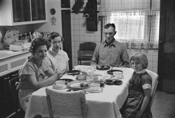 The Ernst G. Kerns family, with Edna, Nancy, Ernest, and Maribeth sitting at a table.