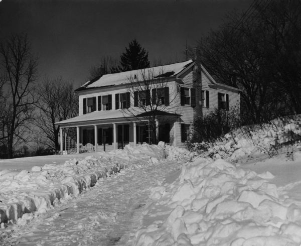 Home of the photographer after a snowstorm. Written on reverse: "Built in 1850, was first station of underground railroad in Wisconsin in Civil War."
