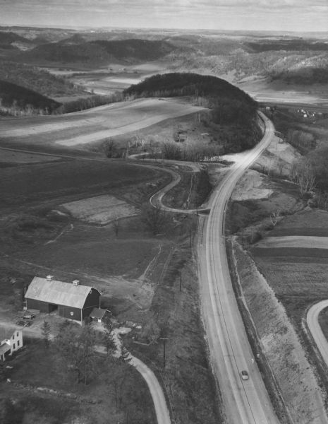 Aerial view of US Highway 14 southeast of La Crosse descending into Mormon Coulee. The original caption of the print, which is undated, describes the road as "one of Wisconsin's modern highways."