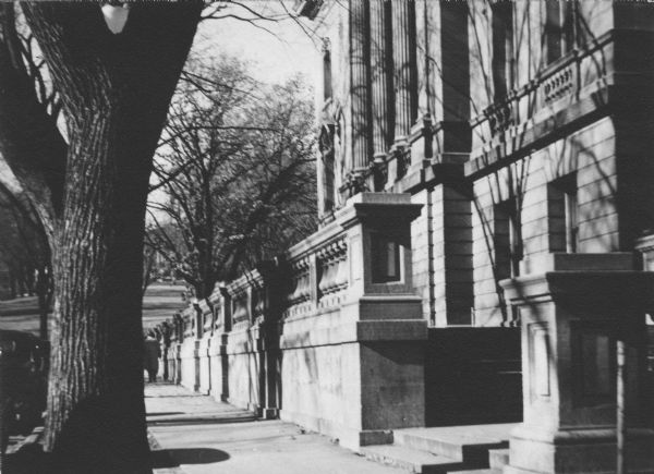 The State Street side of the Wisconsin Historical Society building and sidewalk. A large tree is in the left foreground. Bascom Hill is in the Background.