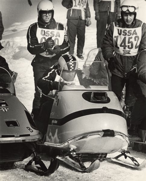 Snowmobiles and drivers lining up before the start of a United States Snowmobile Association sanctioned race. Miller Brewing was a sponsor for the event.