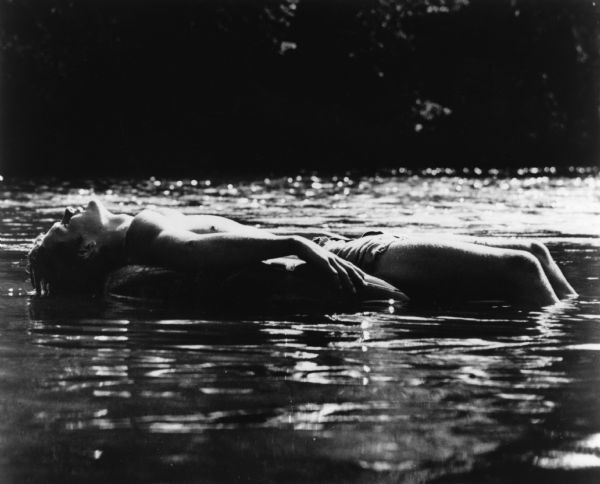 Teen boy resting on an inner tube while floating down the Apple River, a very popular summer activity.