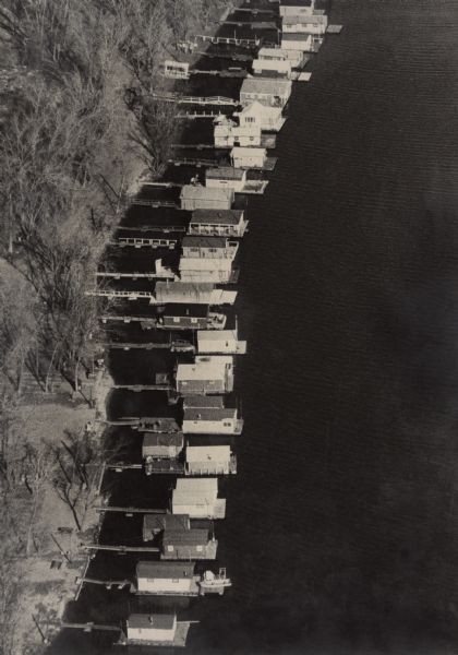 Elevated view of boathouses floating on the water at piers along the shore of the Black River. Some of the boathouses have been owned by many generations of the same family.