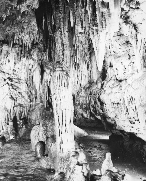 Totem Pole Room at the Cave of the Mounds. Caption on back of print reads: "The Totem Pole Room is popular with visitors because of the rich coloring and rare formations such [sic] the bleeding and black stalactites."