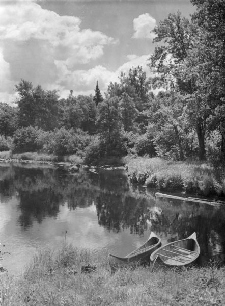 Two canoes are pulled up on the shoreline in the Flambeau River State Forest.
