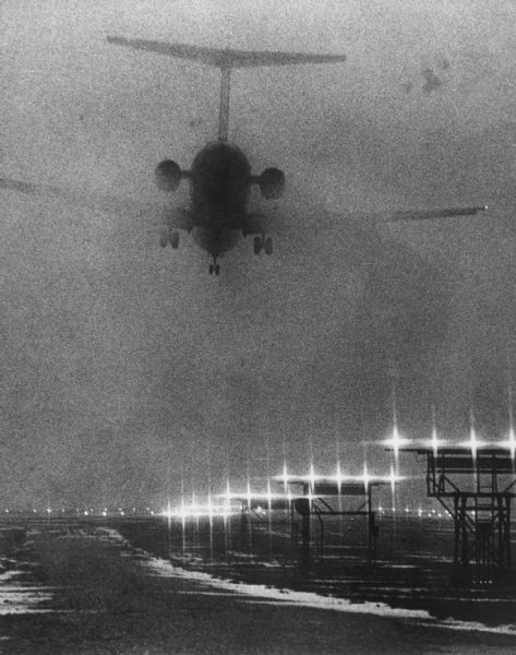 Airplane landing at Mitchell Field in dense fog.
