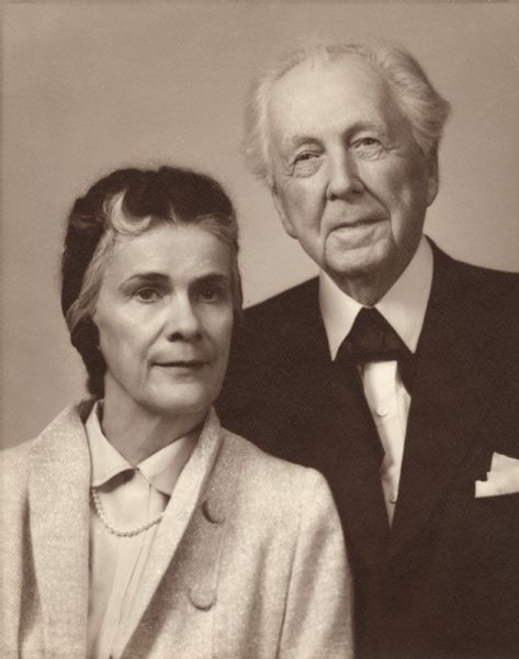 Unretouched portrait of Mr. and Mrs. Frank Lloyd Wright taken at the same time that each sat individually with Reierson for new passport photographs. The photographer's original jacket says "Retouch couple picture, Mrs. Wright mostly."